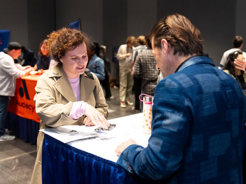Two people are talking over a table.