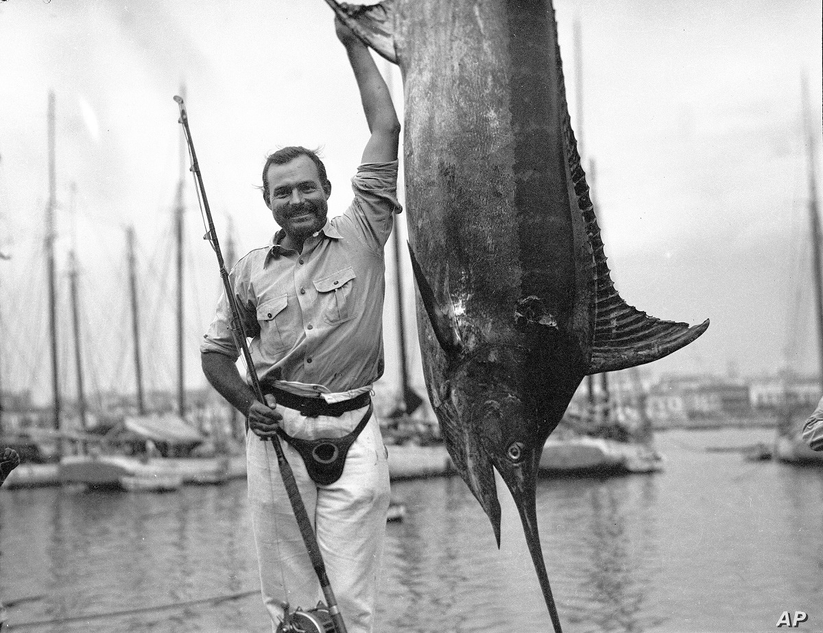Ernest Hemingway poses with a marlin at Havana Harbor, in Key West, Florida, in July 1934. Cr: Ernest Hemingway Photograph Collection. John F. Kennedy Presidential Library and Museum, Boston