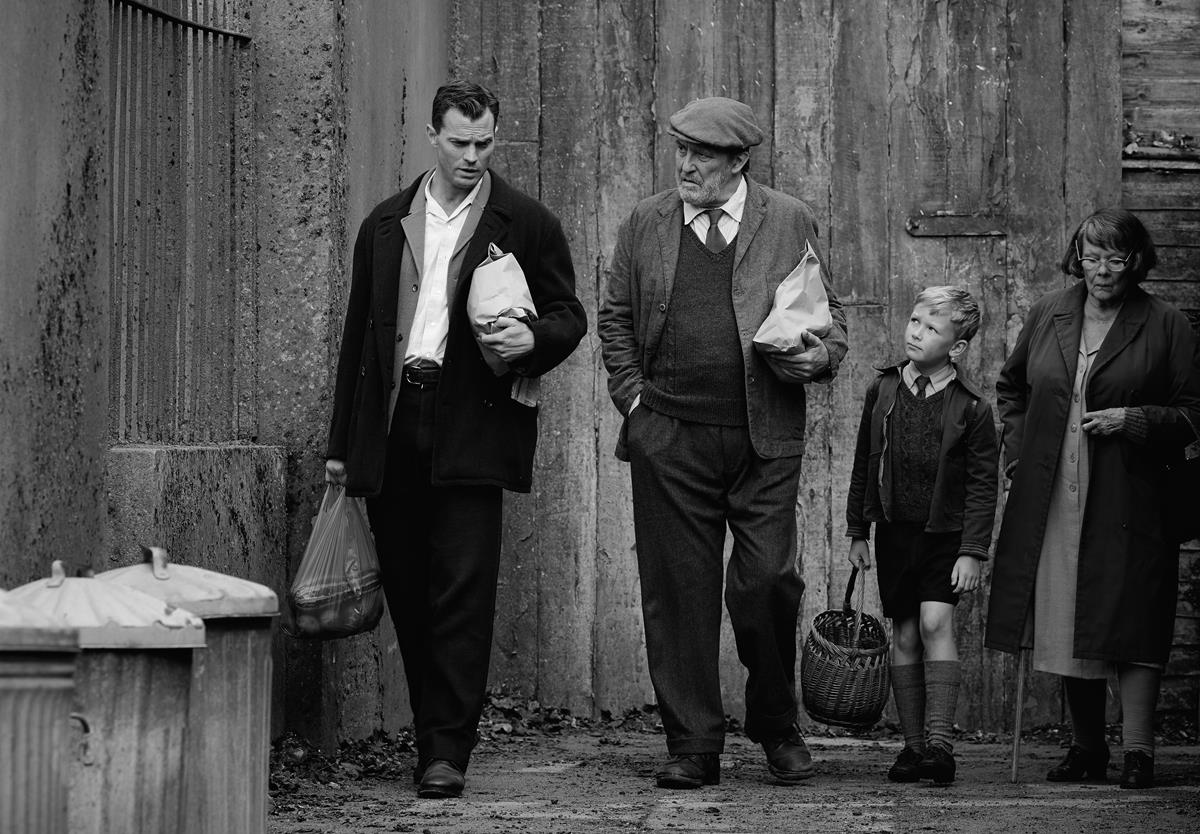 Jamie Dornan as Pa, Ciarán Hinds as Pop, Jude Hill as Buddy, and Judi Dench as Granny in director Kenneth Branagh's “Belfast.” Cr: Focus Features
