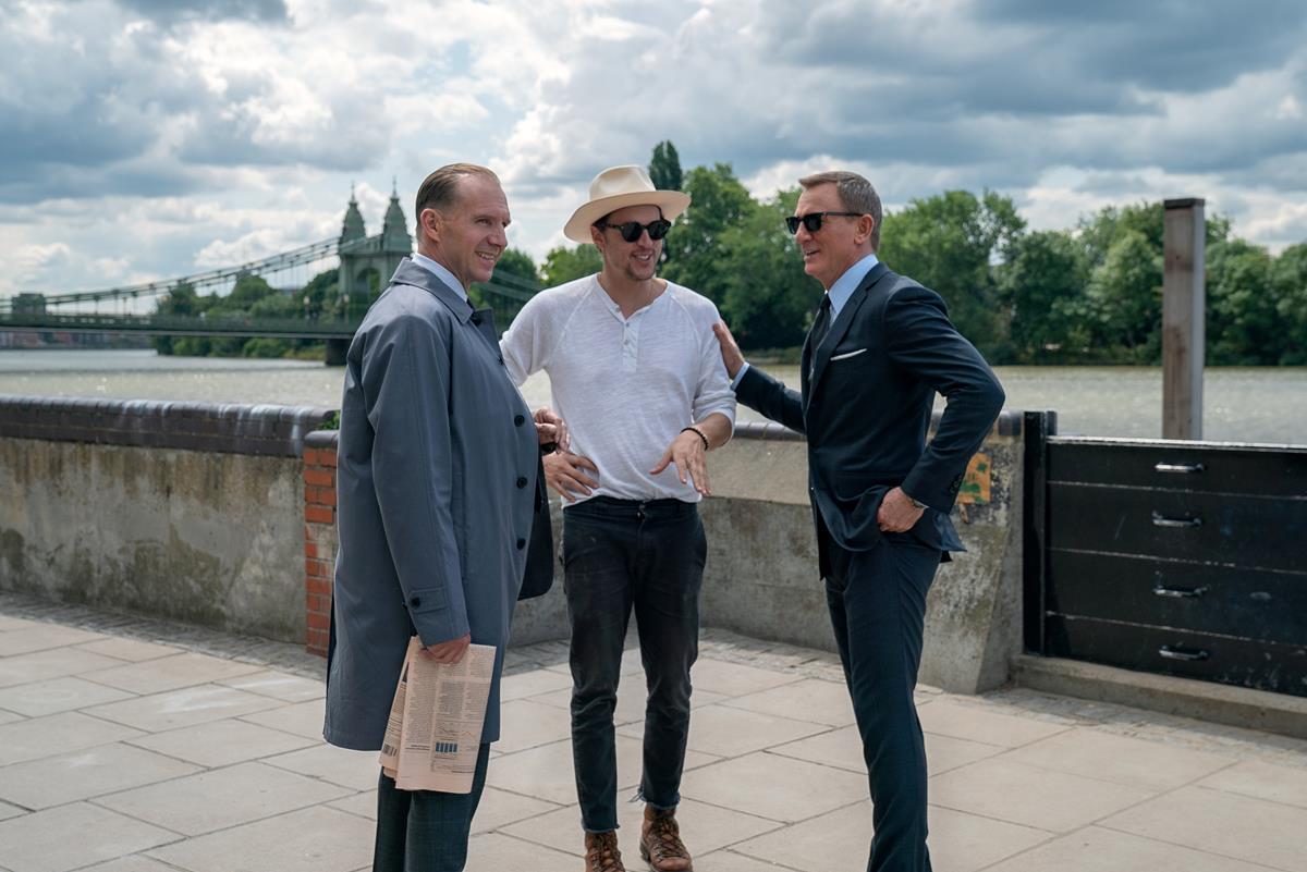 Ralph Fiennes, director Cary Joji Fukunaga, and Daniel Craig on the set of “No Time To Die.” Cr: MGM