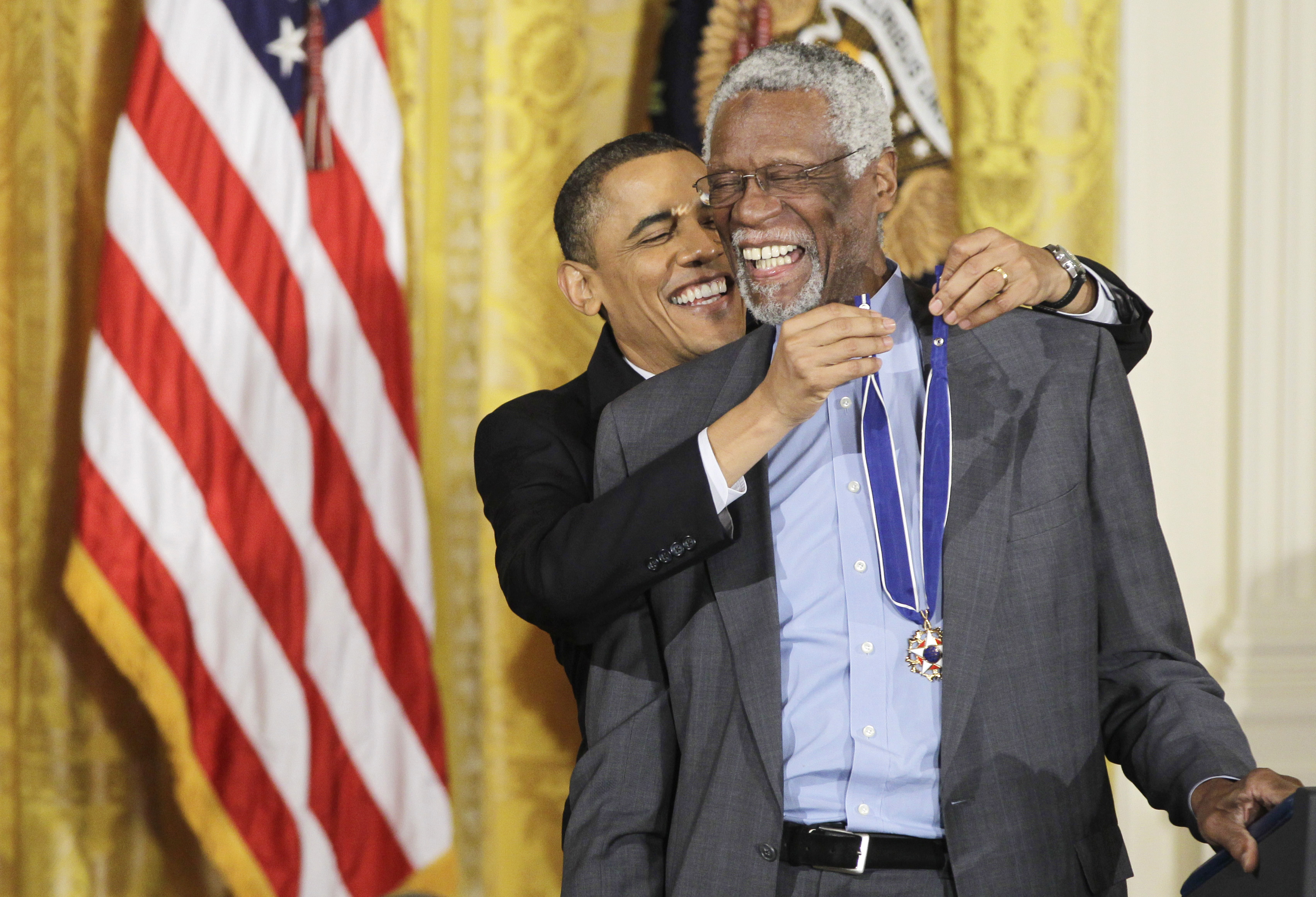 President Barack Obama reaches up to present a 2010 Presidential Medal of Freedom to basketball hall of fame member, former Boston Celtics coach and captain Bill Russell, Tuesday, Feb. 15, 2011, during a ceremony in the East Room of the White House in Washington. cr: Charles Dharapak/AP Images/Courtesy of Netflix